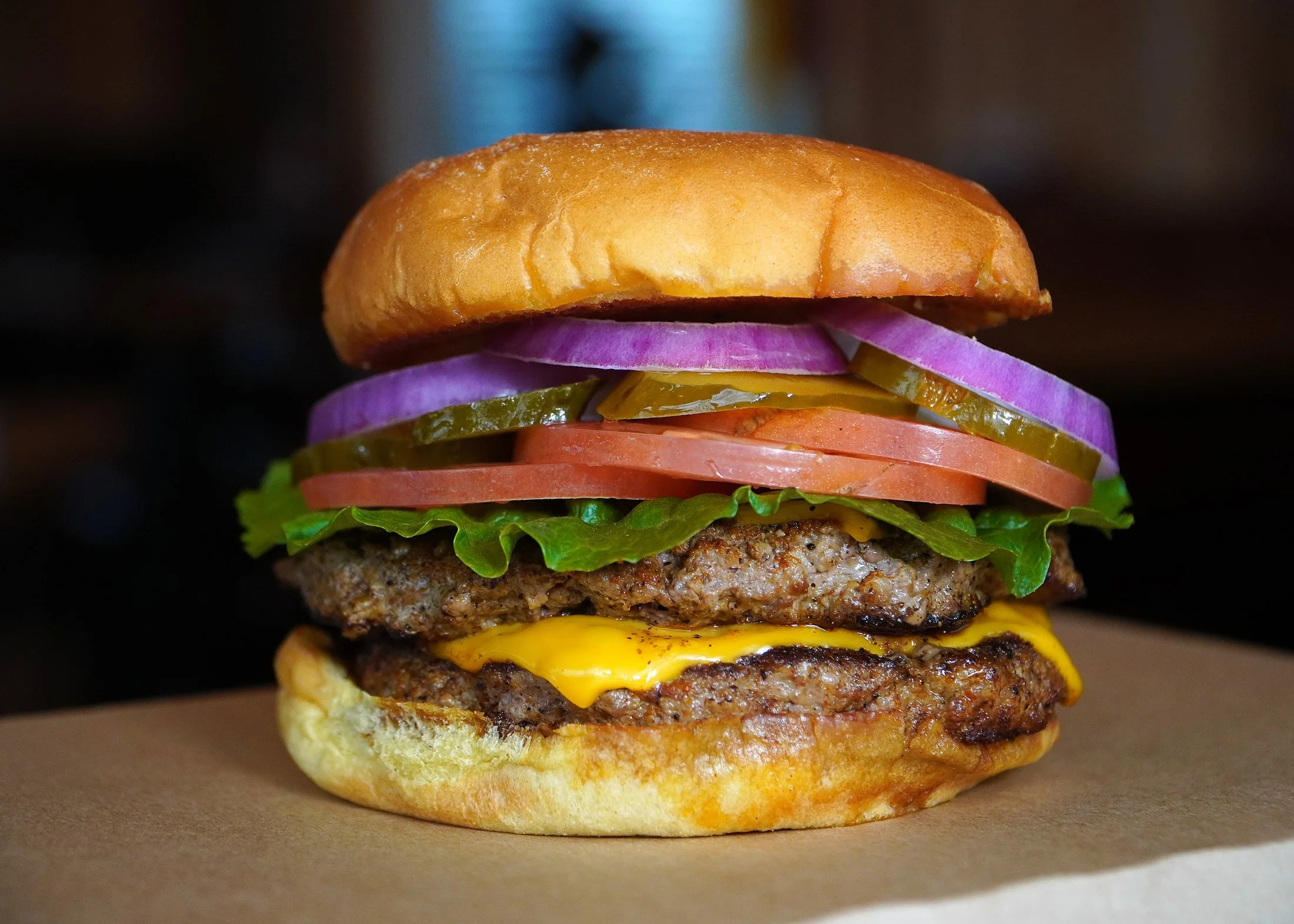 Double whole-ground beef cheeseburger stacked with cheddar, red onion, pickles and tomato