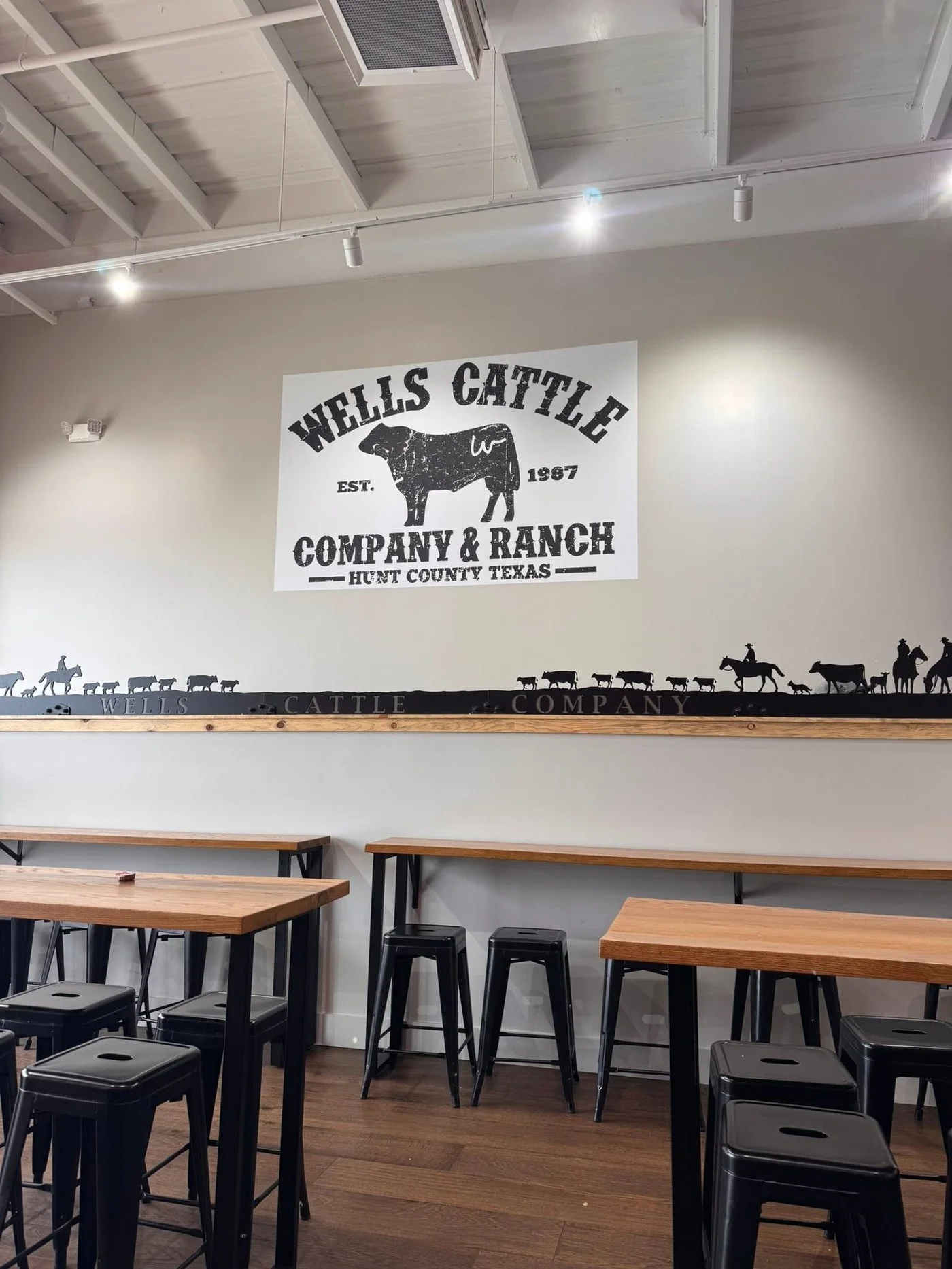 The Wells Cattle Company & Ranch wall inside Wells Burgers Express — est. 1987, Hunt County, Texas
